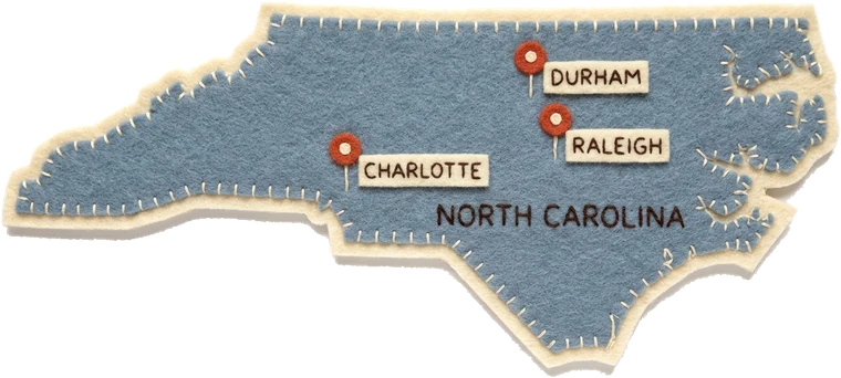 Felt map of North Carolina with pins marking CuePilot schools across Charlotte, Raleigh, Durham and Greensboro